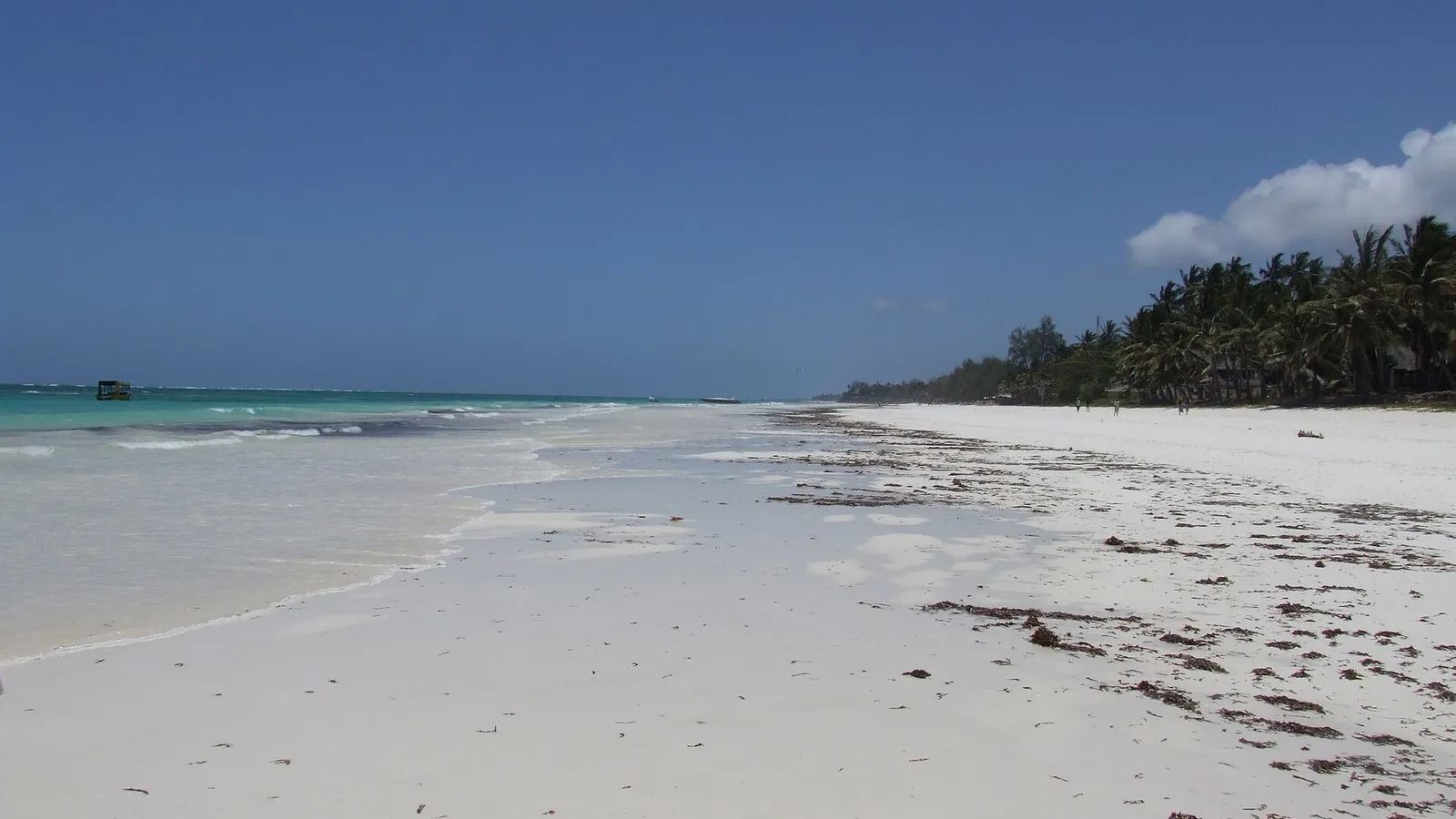 La larga orilla de arena blanca de Diani Beach bajo un cielo azul