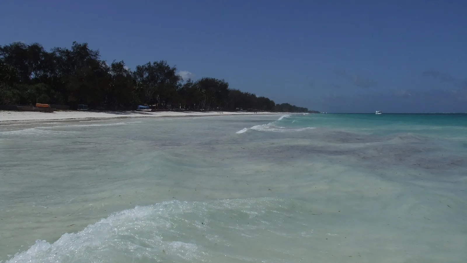 Agua turquesa y transparente en la orilla de Diani Beach