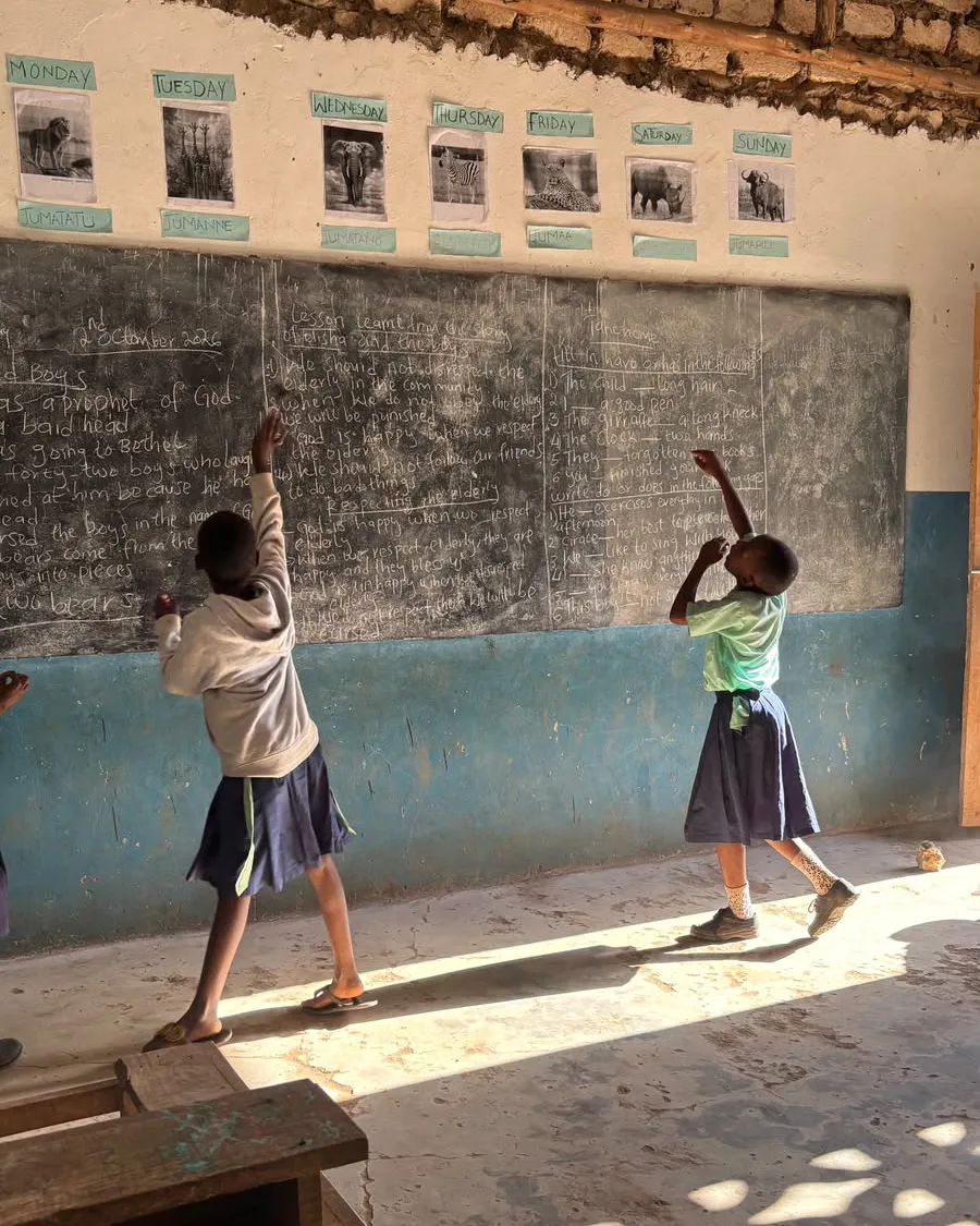 Dos alumnas dibujando en el pizarrón del aula