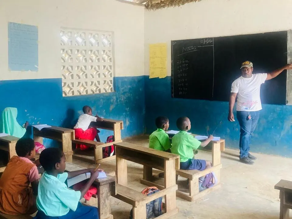 Una clase de matemáticas: el maestro en el pizarrón y los alumnos en sus pupitres