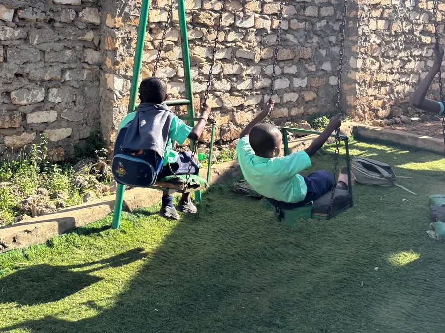 Children playing on the swings in the school yard